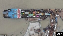This aerial photo shows people board a ferry as authorities order a new lockdown to contain the spread of the Covid-19 coronavirus, in Munshiganj, Bangladesh.