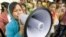 A Cambodian garment worker speaks on a loud speaker as she leads a strike in front of a factory on the outskirts of Phnom Penh, file photo. 