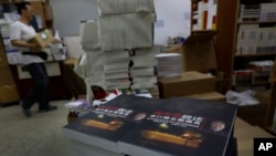 FILE - A worker walks past a stack of books by former Beijing mayor Chen Xitong, titled "Conversation with Chen Xitong," at a publisher's warehouse, one day before the launch of the book in Hong Kong.
