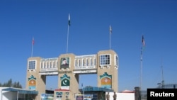 FILE - Soldiers stand by the closed gates of Pakistan's border post, after Pakistan sealed its border with Afghanistan to guard against the spread of the coronavirus, at the Friendship Gate crossing point at Chaman, Pakistan, March 2, 2020.