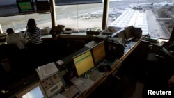 Reagan National Airport air traffic controller Sundie Yukich (2nd L) directs aircraft from the control tower in Washington, Feb. 28, 2013. 
