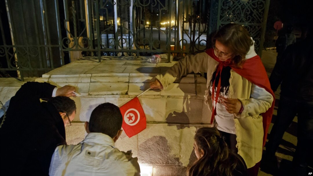Warga Tunisia menyalakan lilin di pintu masuk Museum Nasional Bardo di Tunis, pasca serangan pria bersenjata 18 Maret 2015 (AP Photo/Michel Euler).