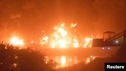 Fire burns after a blast at an oil terminal in Conakry, Guinea, December 18, 2023, in this screengrab obtained from a social media video. 