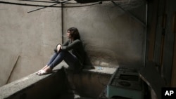Nahal, a 19-year-old transgender woman smokes cigarette on her balcony in Tehran, Iran, April 22, 2018.