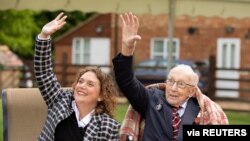 Former British Army Officer Captain Tom Moore and his daughter Hannah wave to a spitfire and hurricane from RAF Coningsby that fly over his house in Bedfordshire, Britain, April 30, 2020. (Emma Sohl/Capture the Light Photography/Handout)
