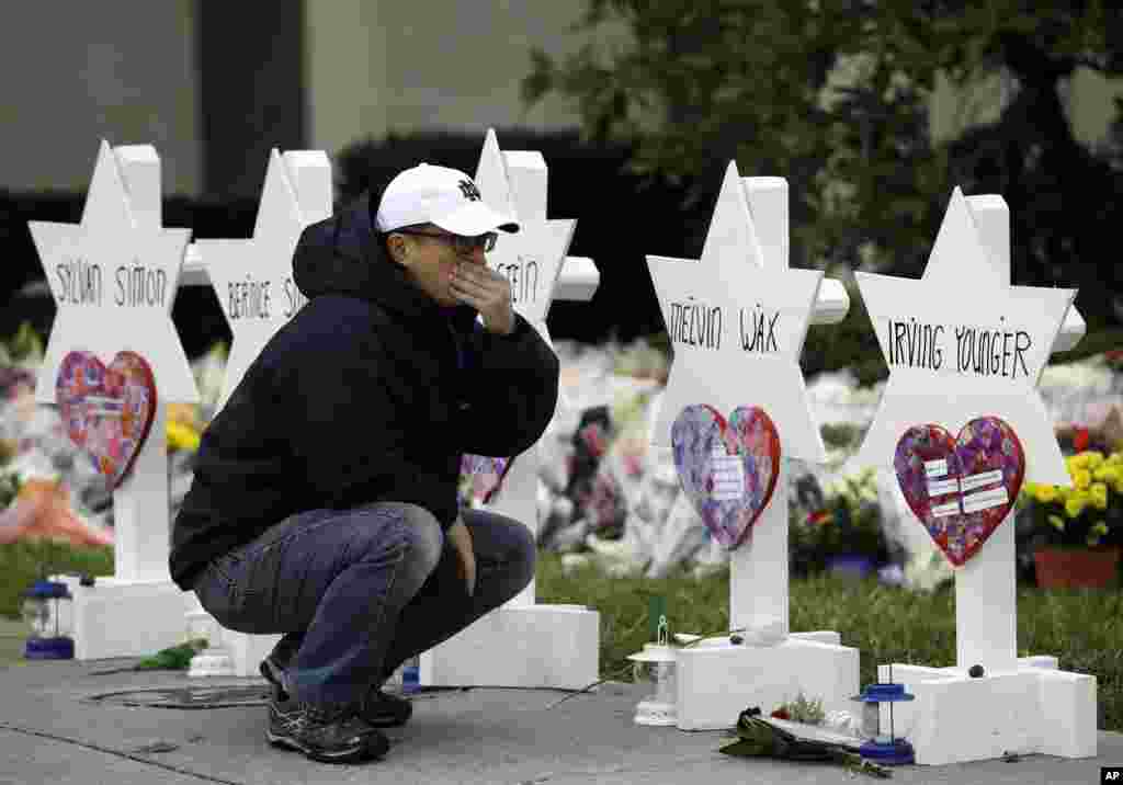 A man reacts in front of Stars of David with the names of those killed in a deadly shooting at the Tree of Life Synagogue, in Pittsburgh, Pennsylvania.