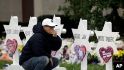 FILE - A person pauses in front of Stars of David with the names of those killed in a deadly shooting at the Tree of Life Synagogue, in Pittsburgh, Pennsylvania, Oct. 29, 2018. 