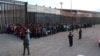 FILE - U.S. Border Patrol agents keep watch on a large group of migrants who they say were attempting to cross the U.S.-Mexico border illegally, in El Paso, Texas, May 29, 2019.