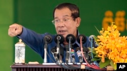 Cambodia's Prime Minister Hun Sen speaks to garment workers during a visit to a factory outside Phnom Penh, Cambodia, Wednesday, Aug. 30, 2017. Hun Sen is on a country-wide trip visiting the nation's factory workers to hear their hopes and concerns in person. (AP Photo/Heng Sinith)