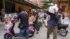 People carry sacks of rice and other food donated by the local government inside a red zone with strict lockdown measures during the latest outbreak of the coronavirus disease (COVID-19) in Phnom Penh, Cambodia, April 30, 2021. REUTERS/Cindy Liu