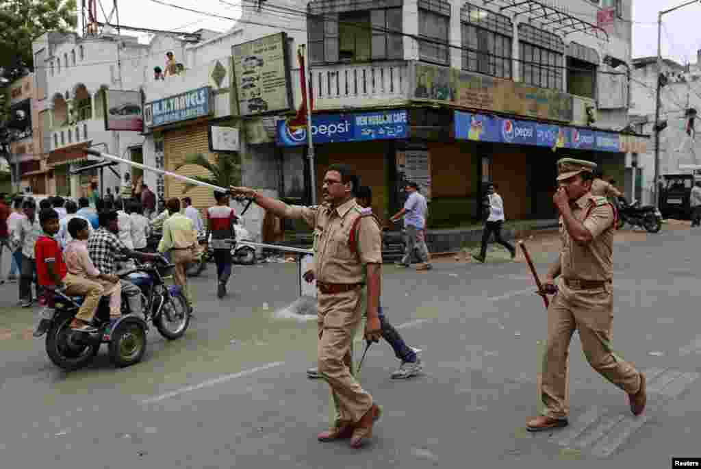 Police chase away onlookers after a minor scuffle between political party workers outside a polling station in southern Indian city of Hyderabad, April 30, 2014. 