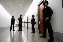 FILE - Capitol Hill police officers stand outside a Senate committee hearing room, on Capitol Hill, in Washington, Oct. 14, 2020.