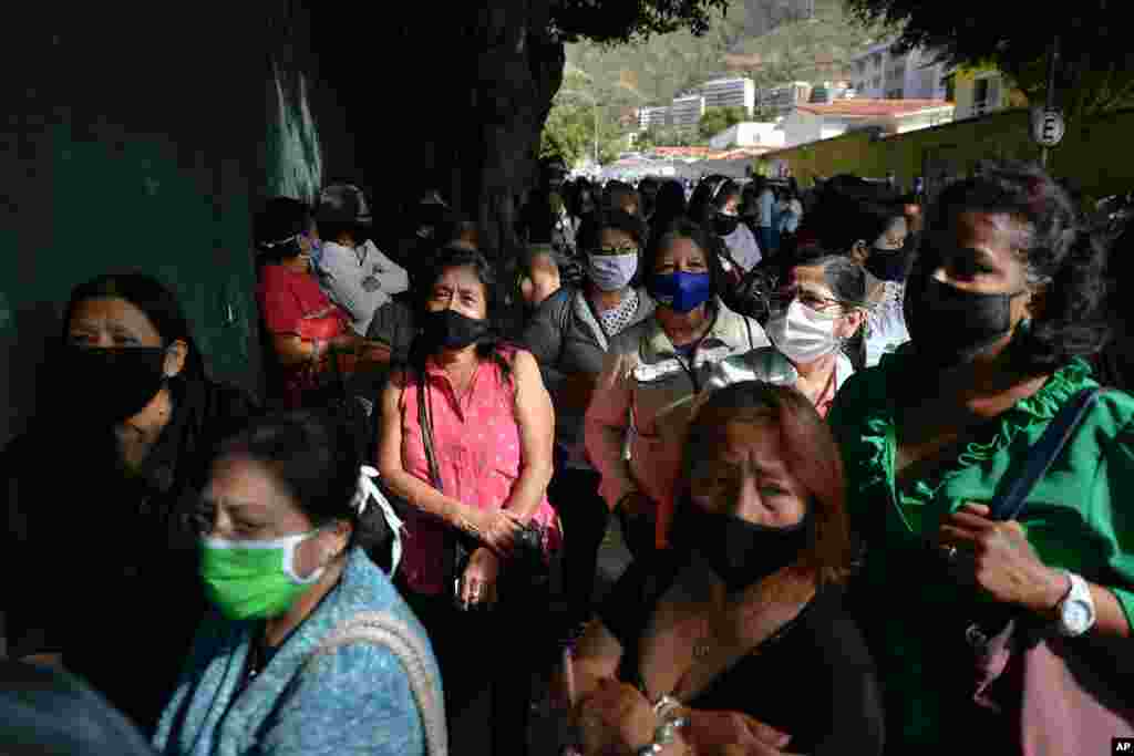 Los ecuatorianos que viven en Venezuela, con m&#225;scaras protectoras para protegerse de la propagaci&#243;n del nuevo coronavirus, esperan ingresar a un colegio electoral en Caracas, Venezuela, el domingo 7 de febrero de 2021. 