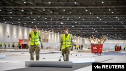 Soldiers from 1 Royal Anglian Regiment assist with the build of the new NHS Nightingale Hospital to fight against the spread of the coronavirus disease (COVID-19), in London, Britain, March 27, 2020.