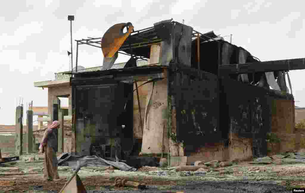 A man inspects damage at an oil refinery and a gas station that were targeted by what activists said were U.S.-led air strikes, in the town of Tel Abyad of Raqqa governorate, near the border with Turkey, Oct. 2, 2014.