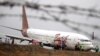 Petugas bandara berdiri di samping pesawat Batik Air Boeing 737-900ER yang tergelincir di Bandara Adi Sucipto Yogyakarta, 6 November 2015 (Foto: ilustrasi / Antara via Reuters)