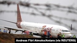 Petugas bandara berdiri di samping pesawat Batik Air Boeing 737-900ER yang tergelincir di Bandara Adi Sucipto Yogyakarta, 6 November 2015 (Foto: ilustrasi / Antara via Reuters)