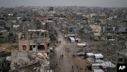 Palestinians walk amid the rubble of destroyed homes and buildings in the Zeitoun neighborhood of Gaza City, March 7, 2025.