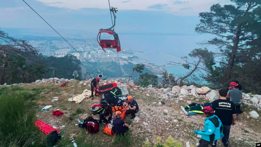 Rescue and emergency workers attend to passengers of a cable car outside Antalya, Turkey, on April 12, 2024. One person was killed and 10 injured when a cable car hit a pole and burst open, sending the passengers plummeting to the mountainside below, officials said.