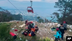 Anggota tim penyelamat dan tim darurat membantu penumpang sistem transportasi gondola di luar Antalya, selatan Turki, pada Jumat, 12 April 2024. (Foto: via AP)