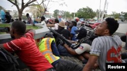 Polisye kap manifeste yo pran abri dèyè yo mi pandan bal ap tire sou Channmas dimanch 23 fevriye 2020. REUTERS/Andres Martinez Casares - RC2L6F9PYSWC