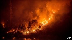 The Caldor Fire burns above the South Fork of the American River in the White Hall community of El Dorado County, Calif., on Aug. 27, 2021.