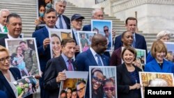 Senate Democrats hold up photographs of families who have conceived children through IVF, ahead of a Senate vote on the 'Right to IVF' bill, introduced by U.S. Senator Tammy Duckworth, on Capitol Hill in Washington, Sept. 17, 2024.