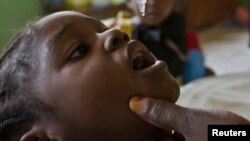 Wata ma'aikaciyar kiwon lafiya tana diga ma yarinya maganin rigakafin Polio a wata makaranta a Abuja, babban birnin Najeriya