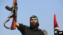 A Libyan rebel fighter celebrates as they drive through Tripoli's Qarqarsh district, August 22, 2011