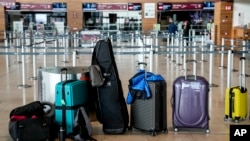 Passengers' luggage is on the floor at the Berlin-Brandenburg airport, during the airports warning strike, March 10, 2025