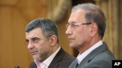The head of Iran's counter-coronavirus task force, Iraj Harirchi, left, speaks at a press briefing with government spokesman Ali Rabiei, in Tehran, Iran, Feb. 24, 2020.