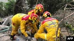 Para anggota tim penyelamat melakukan pencarian di lereng gunung selama pencarian jenazah seorang pejalan kaki di Hualien, sehari setelah gempa besar melanda wilayah timur Taiwan, Kamis (4/4).