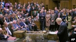 Britain's Prime Minister Boris Johnson delivers a statement to lawmakers inside a crowded House of Commons in London, Oct. 19, 2019. At a rare weekend session, Johnson implored legislators to ratify a last-minute Brexit deal he struck with EU leaders.