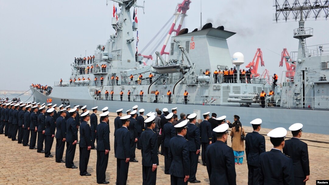 Chinese navy officers (backs to camera) stand in formation as Pakistan naval frigate Shamsher arrives at a military port before a maritime drill during the Western Pacific Naval Symposium in Qingdao, Shandong province, April 20, 2014.
