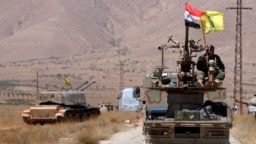 Bendera Hizbullah dan Suriah berkibar di atas kendaraan militer di Qalamoun Barat, Suriah, 28 Agustus 2017. (Foto: Reuters)
​