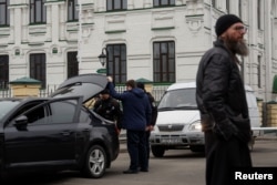 Police officers check a car next to the entrance to compound of the Kyiv Pechersk Lavra monastery, amid Russia's attack on Ukraine, in Kyiv, Ukraine March 16, 2023. (REUTERS/Valentyn Ogirenko)
