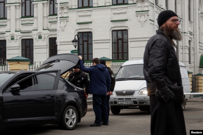 Police officers check a car next to the entrance to compound of the Kyiv Pechersk Lavra monastery, amid Russia's attack on Ukraine, in Kyiv, Ukraine March 16, 2023. (REUTERS/Valentyn Ogirenko)