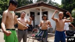 Bapak-bapak di Tangerang, Banten, berjemur pagi hari untuk meningkatkan kekebalan tubuh di tengah wabah Covid-19, 3 April 2020. (Foto: AFP)