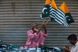 A man sells Kashmir's flags and patriotic memorabilia ahead of Pakistan's Independence Day, in a market in Karachi.