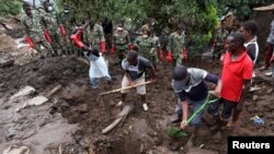 FILE - Members of the Malawian Army and locals help the community to recover bodies of victims in Chimwankhunda township in the aftermath of Tropical Cyclone Freddy in Blantyre, Malawi, March 17, 2023.