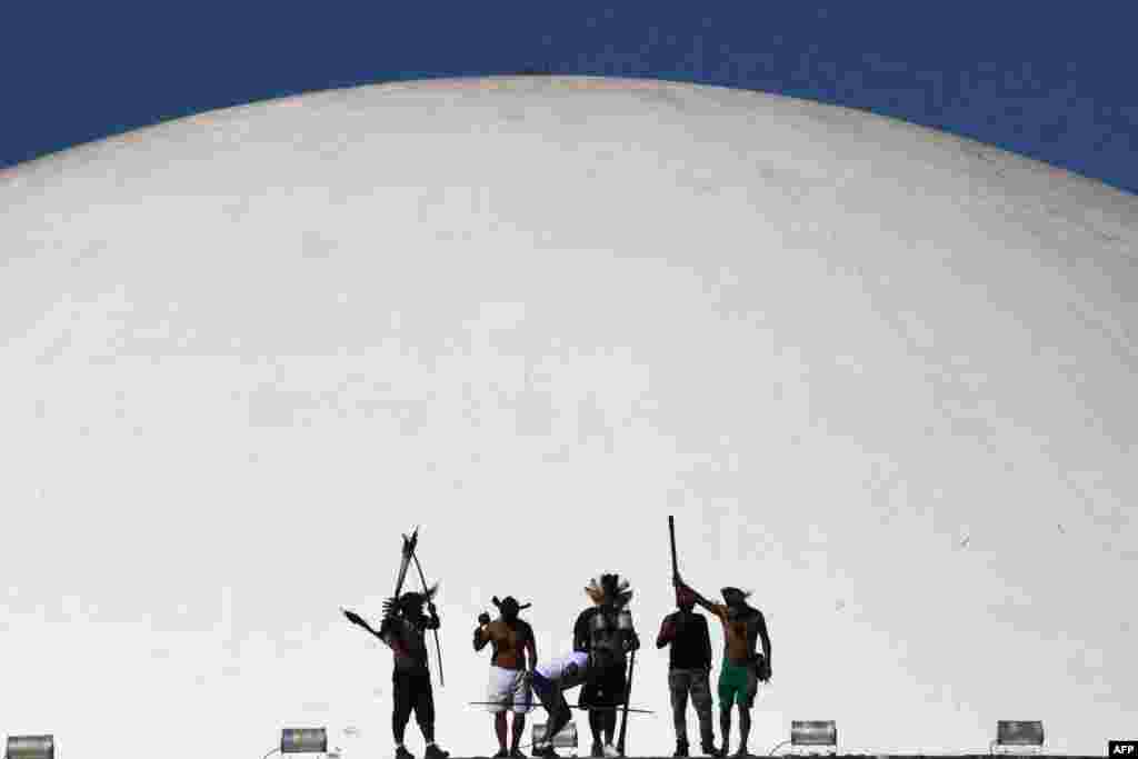 Indigenous people in Brazil from different tribes protest a bill under discussion in the Deputies Chamber that would change the rules of the indigenous territories demarcation, at the top of of the National Congress building in Brasilia, June 8, 2021.