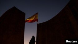 Une femme se tient près d'un drapeau espagnol sur la Place Colon à la veille des élections régionales en Catalogne à Madrid, le 20 décembre 2017.