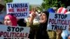 FILE - Supporter of the leader of the Ennahdha party Rached Ghannouchi, hold placards as they stage a protest at Tunisia's anti-terrorism unit in Tunis, Tunisia, Tuesday, July 19, 2022. 