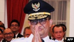 Akademisi dan mantan Menteri Pendidikan Anies Baswedan menyambut para pendukungnya ketika pelantikannya menjadi Gubernur DKI Jakarta di istana Presiden di Jakarta, 16 Oktober 2017. (Foto: AFP)