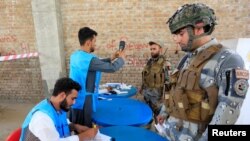 Polisi Afghanistan tiba untuk memberikan suara mereka dalam pemilihan presiden di Jalalabad, Afghanistan 28 September 2019. (Foto: Reuters/Parwiz)