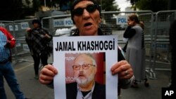 សកម្មជនសិទ្ធិមនុស្សម្នាក់​កាន់​រូប​អ្នកកាសែតអារ៉ាប៊ី សាអូឌីត ដែល​បានបាត់ខ្លួន លោក Jamal Khashoggi។