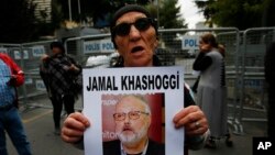 FILE - A member of the Human Rights Association Istanbul branch, holds a poster with a photo of missing Saudi journalist Jamal Khashoggi, during a protest in his support near the Saudi Arabia consulate in Istanbul, Oct. 9, 2018.