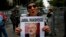 FILE - A member of the Human Rights Association Istanbul branch, holds a poster with a photo of missing Saudi journalist Jamal Khashoggi, during a protest in his support near the Saudi Arabia consulate in Istanbul, Oct. 9, 2018.
