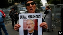 A member of the Human Rights Association Istanbul branch, holds a poster with a photo of missing Saudi journalist Jamal Khashoggi, during a protest in his support near the Saudi Arabia consulate in Istanbul, Oct. 9, 2018.