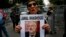 A member of the Human Rights Association Istanbul branch, holds a poster with a photo of missing Saudi journalist Jamal Khashoggi, during a protest in his support near the Saudi Arabia consulate in Istanbul, Oct. 9, 2018.